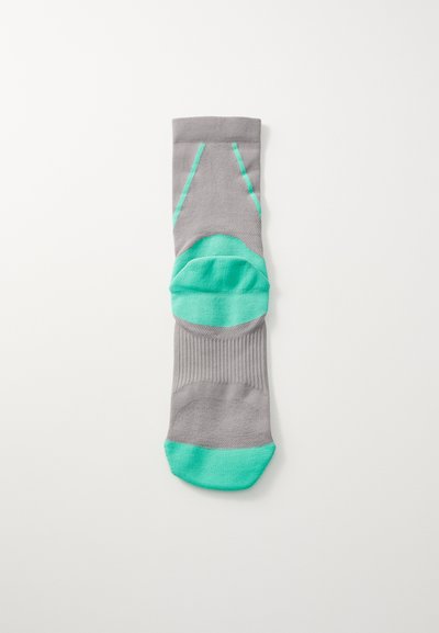 Calcetín gris con un tejido texturizado, que presenta acentos en turquesa brillante en la punta, el talón y los laterales, diseñado para la durabilidad y la comodidad.