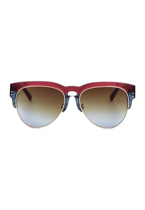 Occhiali da sole con montatura semicerchiata rossa e blu e lenti scure sfumate, mostrati frontalmente su sfondo bianco.