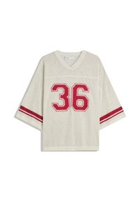 T-shirt de sport en maille surdimensionné couleur crème avec des accents rouges, présentant des manches courtes et le numéro 36 affiché en évidence sur le devant.