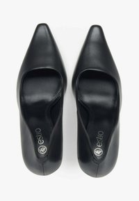 Czarne skórzane buty na wysokim obcasie z końcówką w szpic i otwartymi bokami. Gładka faktura z srebrnym brandingiem na wkładce.