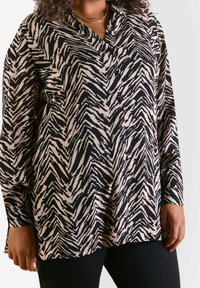 Langsleeve button-up shirt in een zwart en crème zigzagprint, met een kraag en een relaxte pasvorm. Zachte, lichte stof.