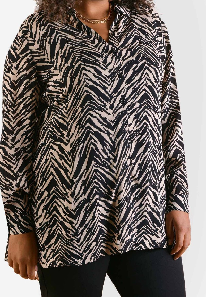 Langsleeve button-up shirt in een zwart en crème zigzagprint, met een kraag en een relaxte pasvorm. Zachte, lichte stof.