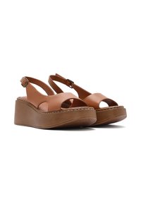 Sandali con zeppa in pelle marrone chiaro, design open-toe, cinturino alla caviglia regolabile e suola in TPU marrone testurizzata. Dettagli cuciti decorano i bordi.