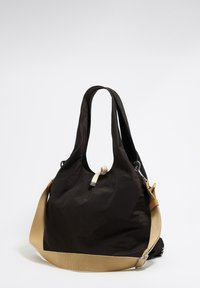 Czarna nylonowa torba na ramię z dwoma krótkimi uchwytami, długim beżowym paskiem i boczną kieszenią. Gładka struktura o minimalistycznym designie.