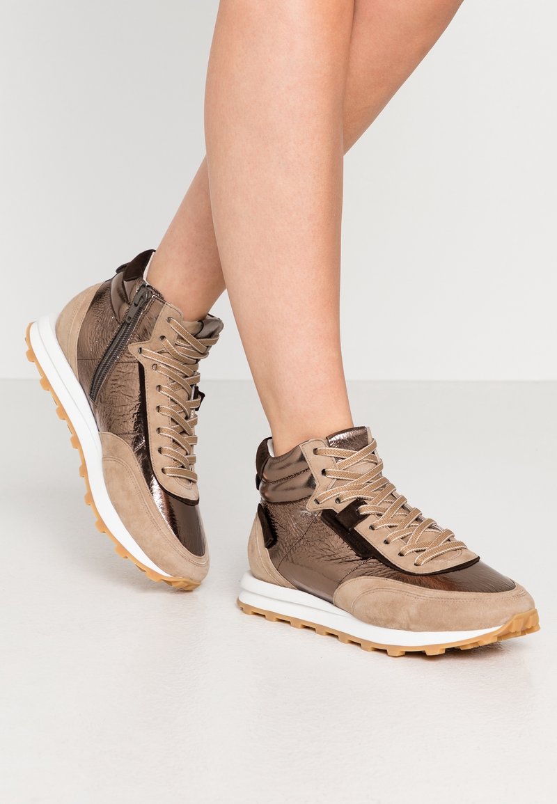 Wysokie sneakersy wykonane z mieszanki brązowego zamszu i metalicznych materiałów, o fakturowanym wzorze, z przodem na sznurowadła i gumową podeszwą zapewniającą przyczepność.