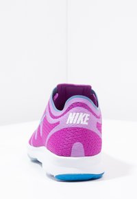 Tenisky Nike s síťovaným svrškem v jasně růžové barvě a levandulovými akcenty. Bílé logo a modrá podrážka dotvářejí design.