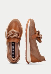 Bruna nätinstegsskor med en flätad knutdetalj, texturerade läderdetaljer och en kontrasterande vit sula.