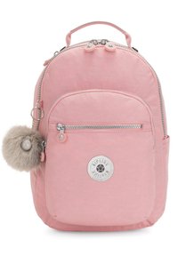 Mochila de nailon rosa con forma redondeada, que cuenta con un bolsillo frontal, herrajes plateados, un accesorio de pom-pom de piel sintética y una insignia de logo circular.