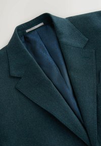 Villasegune villasegude segu dark teal värvuses, millel on narmastega krae, sinine mustriga vooder ja üks rinnatasku, millel on stiilne viimistlus.