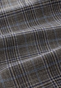 Țesătură gri în carouri, cu un amestec de linii gri închis și albastre, având o textură fină și o greutate moderată, potrivită pentru confecționarea hainelor.