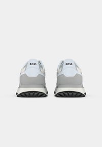 Zapatillas azul claro y gris con una superficie texturizada, que presentan una suela de goma negra y la marca "BOSS" en la parte trasera.