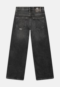 Černé široké džíny s vybledlým povrchem, se dvěma zadními kapsami a nášivkou s logem na pasu. Hladká denimová textura.