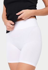 Vita shapewear-shorts med en slät tygtextur och hög midjeband, designade för komfort och stöd.