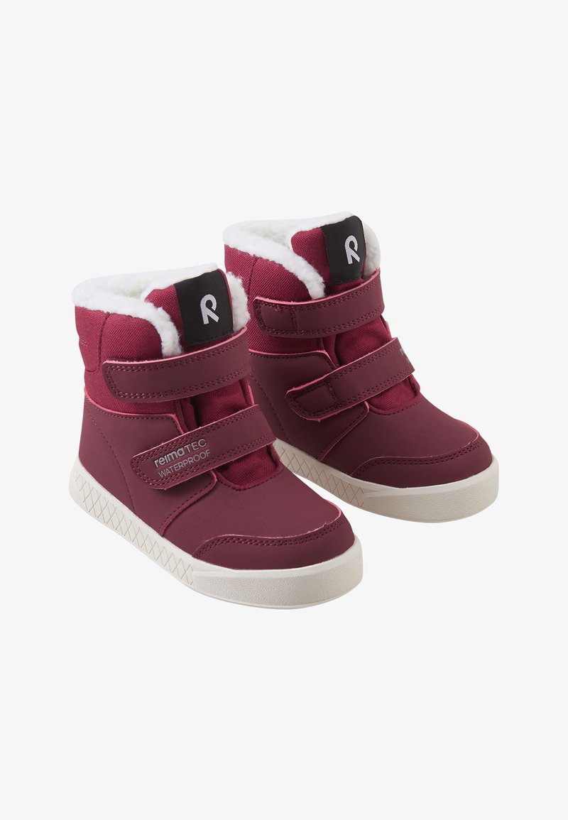 Bottes bordeaux imperméables avec doublure blanche en peluche, dotées de deux straps en velcro, d'un patch logo noir et d'une semelle blanche texturée.