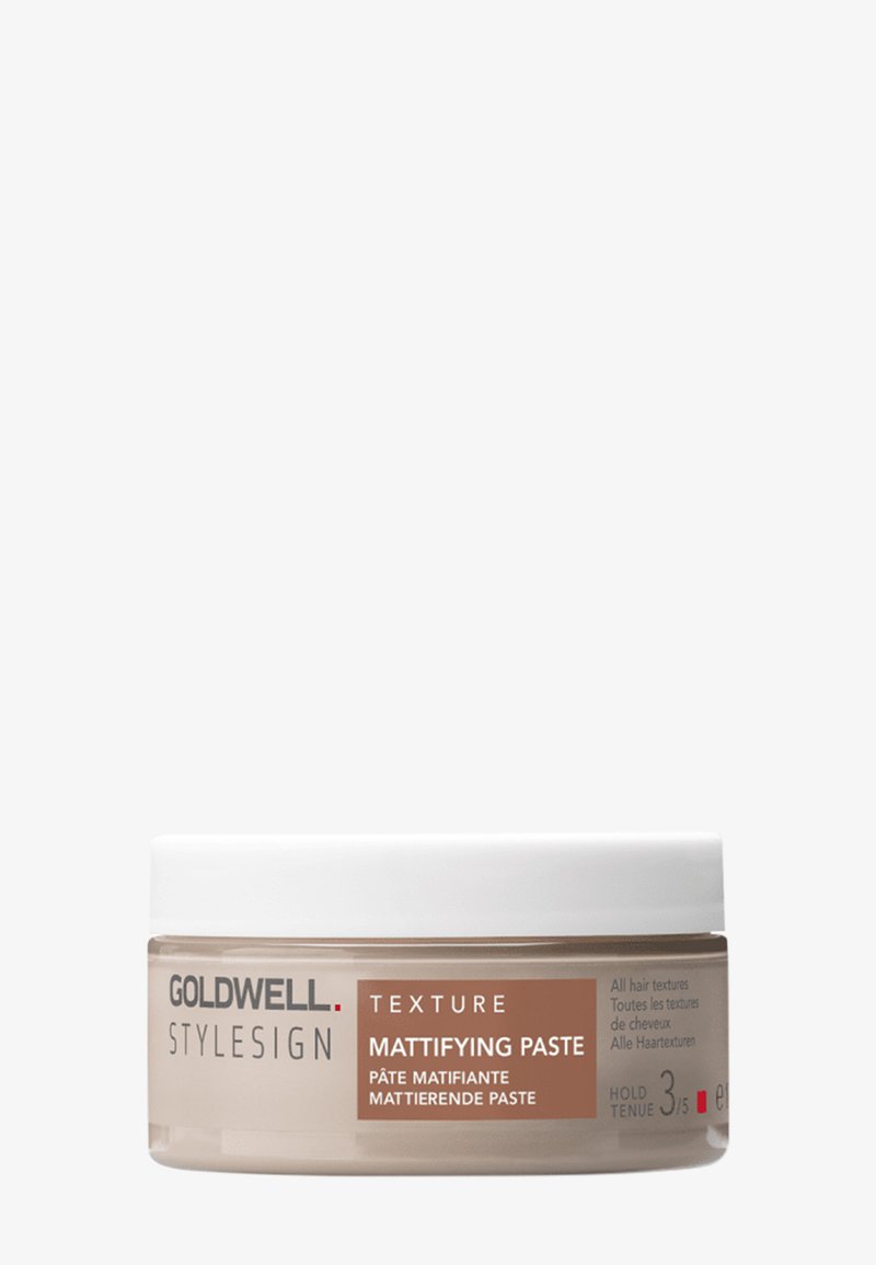 Pâte matifiante Goldwell Stylesign Texture dans un petit récipient rond avec un couvercle blanc, conçue pour tous types de cheveux, tenue niveau 3 sur 5.