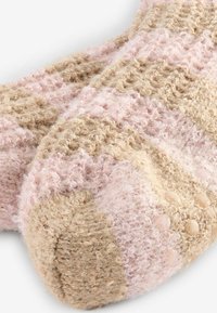 Värmande stickade strumpor i beige och mjuk rosa, med en blandad textur av upphöjda prickar och en mysig, fluffig finish.