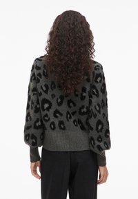 Πλεκτό πουλόβερ σε σκούρο γκρι με μαύρο λεοπάρ σχέδιο. Διαθέτει ριμπ τελείωμα και μανσέτες. Μαλακή υφή, χαλαρή εφαρμογή και μανίκια μπαλονιού.