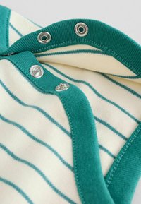 Vihreä raidallinen puuvillabody hopeaisilla napituslahkeilla ja kontrastivärisellä teal-kaula-aukolla. Ominaisuutena ohuet pystysuorat raidat kermakankaan taustalla.