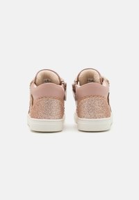Rosa sneakers med glitrende bakside, scalloped design på sidene og myk innermateriale. Har en hvit såle og glidelås lukking.