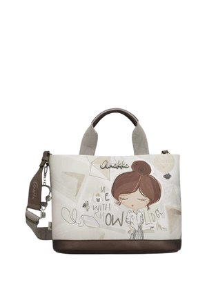 Borsa con base e manici marroni, corpo beige con una ragazza dei cartoni animati con acconciatura a chignon e testo "Innamorata della conoscenza."