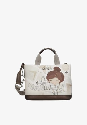 Borsa con base e manici marroni, corpo beige con una ragazza dei cartoni animati con acconciatura a chignon e testo "Innamorata della conoscenza."