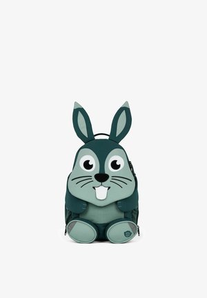 Children's backpack shaped and designed like a green cartoon rabbit with large eyes, ears, a nose, whiskers, and two front teeth.