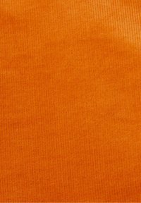 Tissu en velours côtelé orange avec de fines côtes verticales, texture lisse et saturation riche des couleurs. Convient pour les vêtements ou la tapisserie.
