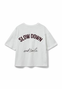 Valge puuvillane T-särk lühikeste varrukatega, millel on tagaküljel maroonivärvi tekst "SLOW DOWN" plokk-kirjas ja "and smile" kursiivis.