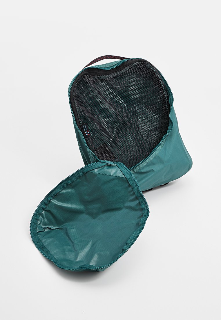 Tealfarbener Reißverschlussbeutel mit einem Netzoberteil. Abnehmbarer runder Boden; glattes, leichtes Gewebe mit subtiler Eleganz, ideal zur Organisation.