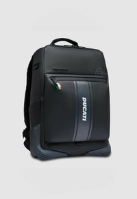 Mochila con un diseño elegante en negro, hecha de material sintético. Cuenta con un compartimento con cremallera, detalles en gris y la marca Ducati.