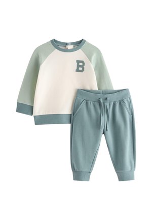 Kleinkinder-Outfit mit hellgrünen Raglanärmeln und Sweatshirt mit Kragen und Buchstabe "B" sowie passenden hellgrünen Hosen mit Kordelzug.