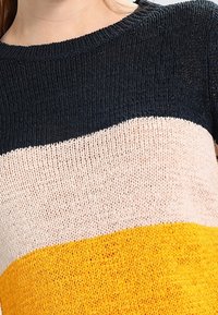 Strickpullover mit horizontalen Streifen in Marineblau, Beige und Gelb. Die Textur ist grob, mit einem Rundhalsausschnitt und lässiger Passform.