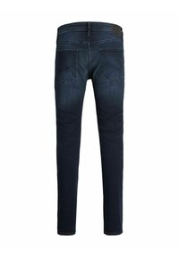 Sötétkék, slim fit farmernadrág, hátsó zsebekkel, finom viselési nyomokkal és bőrből készült logóval a derékrészen.