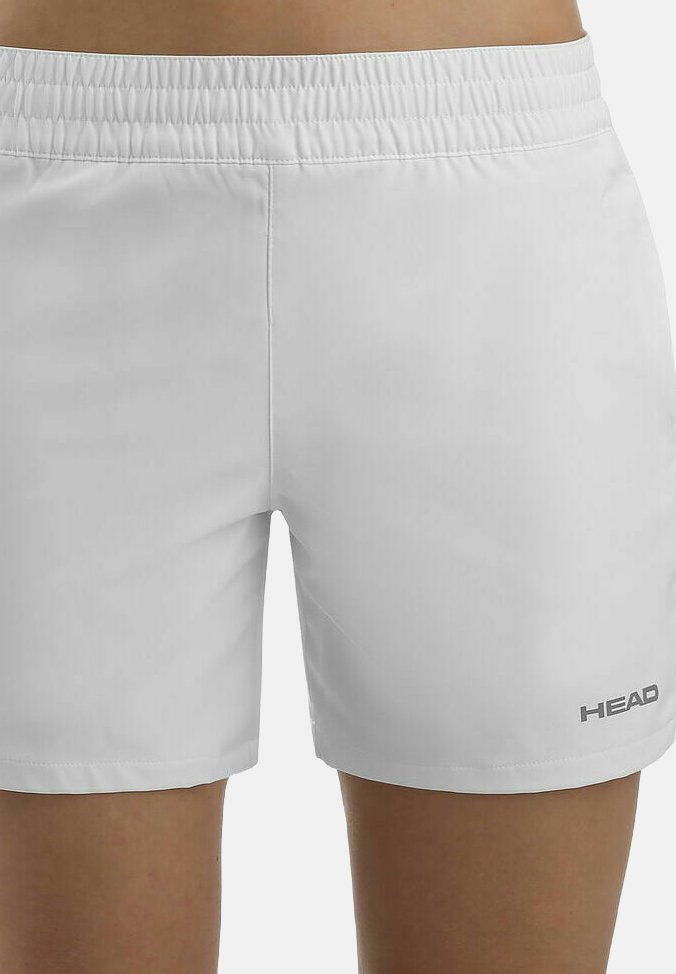 Pantalones cortos deportivos blancos con cintura elástica, llevados en la parte inferior del cuerpo, con pequeño logo "HEAD" en el muslo izquierdo.