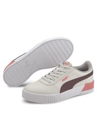 Baskets synthétiques beiges avec une finition texturée, accents marron et roses, lacets plats et semelle blanche rainurée. Logo PUMA sur le côté.