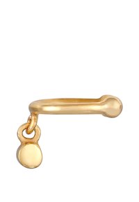 Anillo de metal dorado con forma redondeada y un pequeño charm redondo sujeto por un lazo. Textura suave con un acabado pulido.