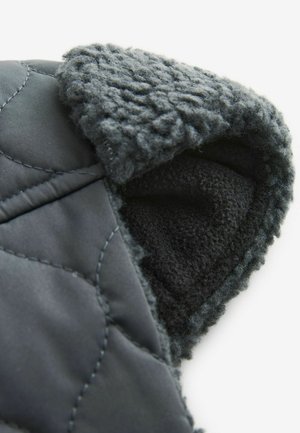 Chaqueta acolchada negra con una capucha de felpa gris, suave y forrada, que presenta una textura exterior lisa y una tela interior en contraste.