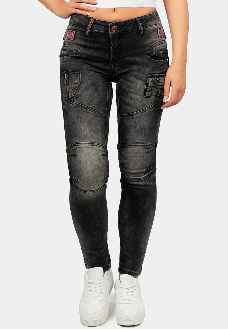 Jeans skinny neri sbiaditi con tasche con zip, pannelli testurizzati e una vestibilità aderente. Accentuati da un logo visibile e un bottone a contrasto.