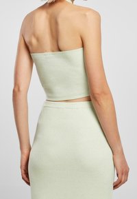 Top corto a coste verde menta abbinato a una gonna coordinata, caratterizzato da un design aderente e una trama morbida. Linee pulite con un aspetto minimalista.