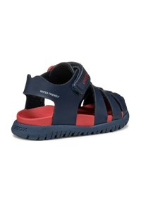 Sandali acquatici navy e rossi con una morbida soletta, design aperto, cinturino regolabile in Velcro e suola in gomma blu teksturizzata.