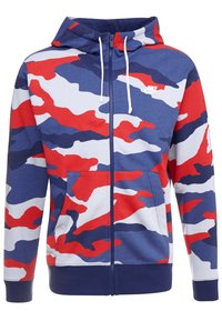 Röd, vit och blå camoslagningsmönstrad zip-up hoodie, med en snörning i huvan, framfickor och ribbade ärmslut. Tyget verkar mjukt.