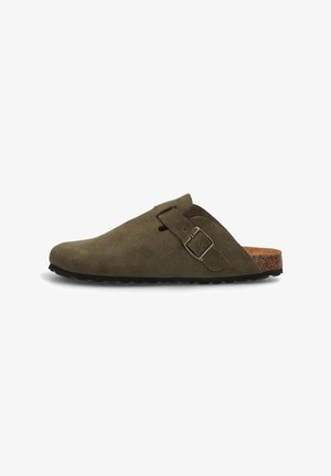 Zapato slip-on de ante verde oliva con punta redonda, correa ajustable con hebilla y plantilla de corcho natural, que presenta una suela texturizada para mejor agarre.