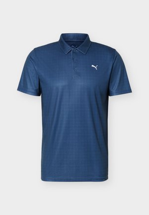 Polo de manga corta azul marino con una tapeta de tres botones y logo blanco de Puma en el pecho izquierdo.