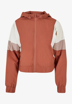 Rūsganas īsās jakas ar kapuci, ar baltām un gaiši rozā paneļu akcentiem, priekšējo rāvējslēdzēju un elastīgām aprocēm. Tekstūrēts materiāls.