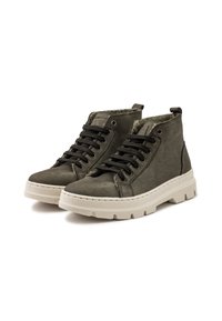 Zapatillas altas de color verde oliva hechas de ante con una suela de goma blanca. Presentan cordones negros y un forro acolchado para mayor comodidad.