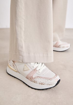 Sneaker bianco con accenti rosa e stampa monogram beige. Presenta un inserto dorato sul tallone, una suola testurizzata e lacci bianchi su una superficie piatta.