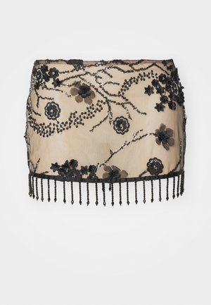 Black embellished mini skirt with floral appliqués, sequins, and a beaded fringe hem. Made from sheer material with intricate detailing.
