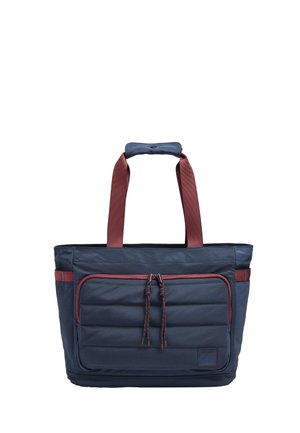 Granatowa torba na ramię z dużą przednią kieszenią na zamek, czerwonymi akcentami, wyściełanymi uchwytami i plecionymi zawieszkami zamka.