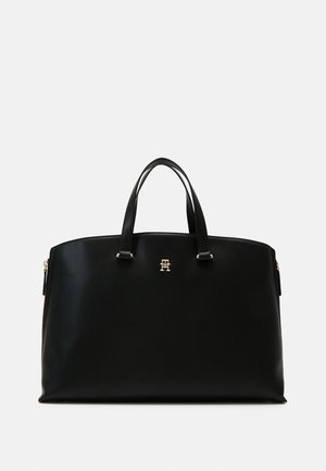 Schwarze Lederhandtasche mit zwei Griffen und einem kleinen goldenen Logo, das zentriert nahe der oberen Vorderseite platziert ist.
