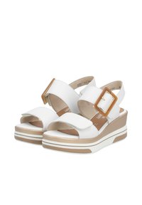 Sandales blanches à talon compensé avec une large sangle et une boucle réglable à la cheville. Elles disposent d'une semelle intérieure beige et d'une plateforme bicolore avec des détails texturés.